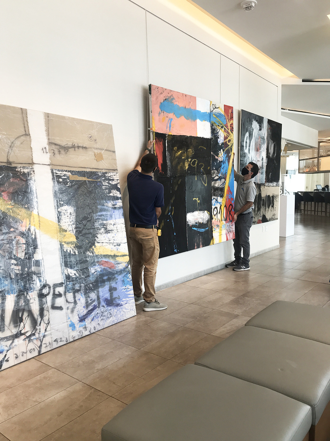 Mounting a large canvas by Jorge Luis Santos with care.
